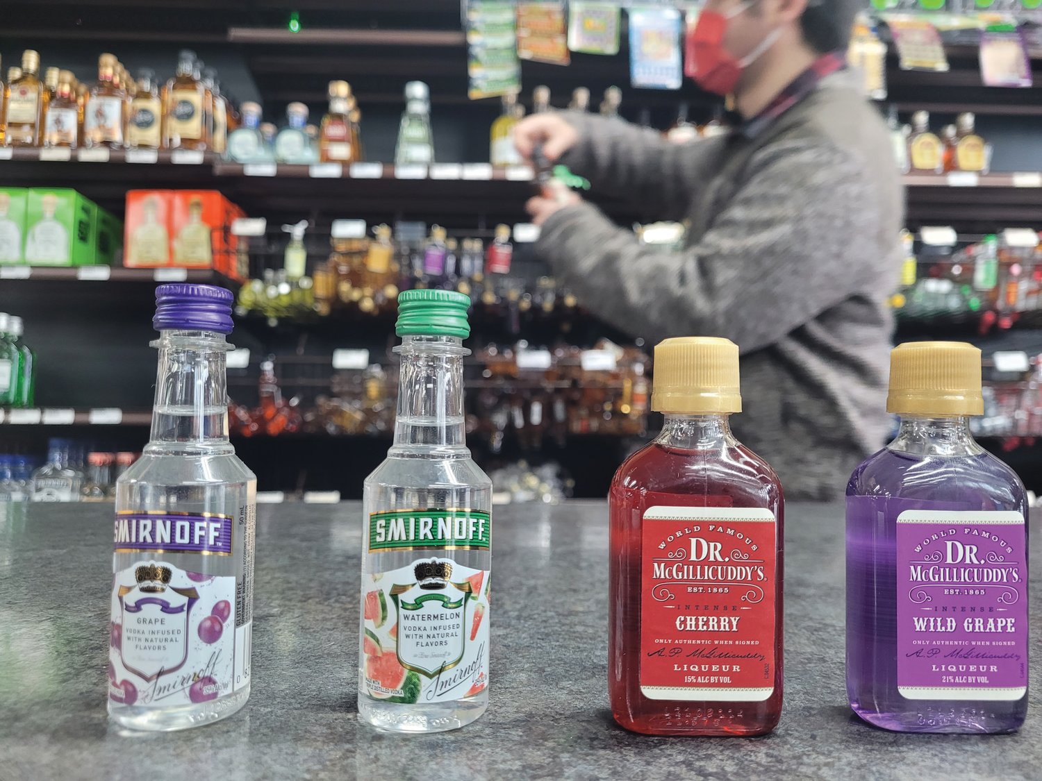 LIQUOR LINEUP: Nick Fonseca, a cashier at Market Beer Wine Spirits in Johnston, lined up a few popular nip selections on the counter. The store’s owner, Norm Hale, says banning nips would be ‘a mixed bag’ for his business and the community.
